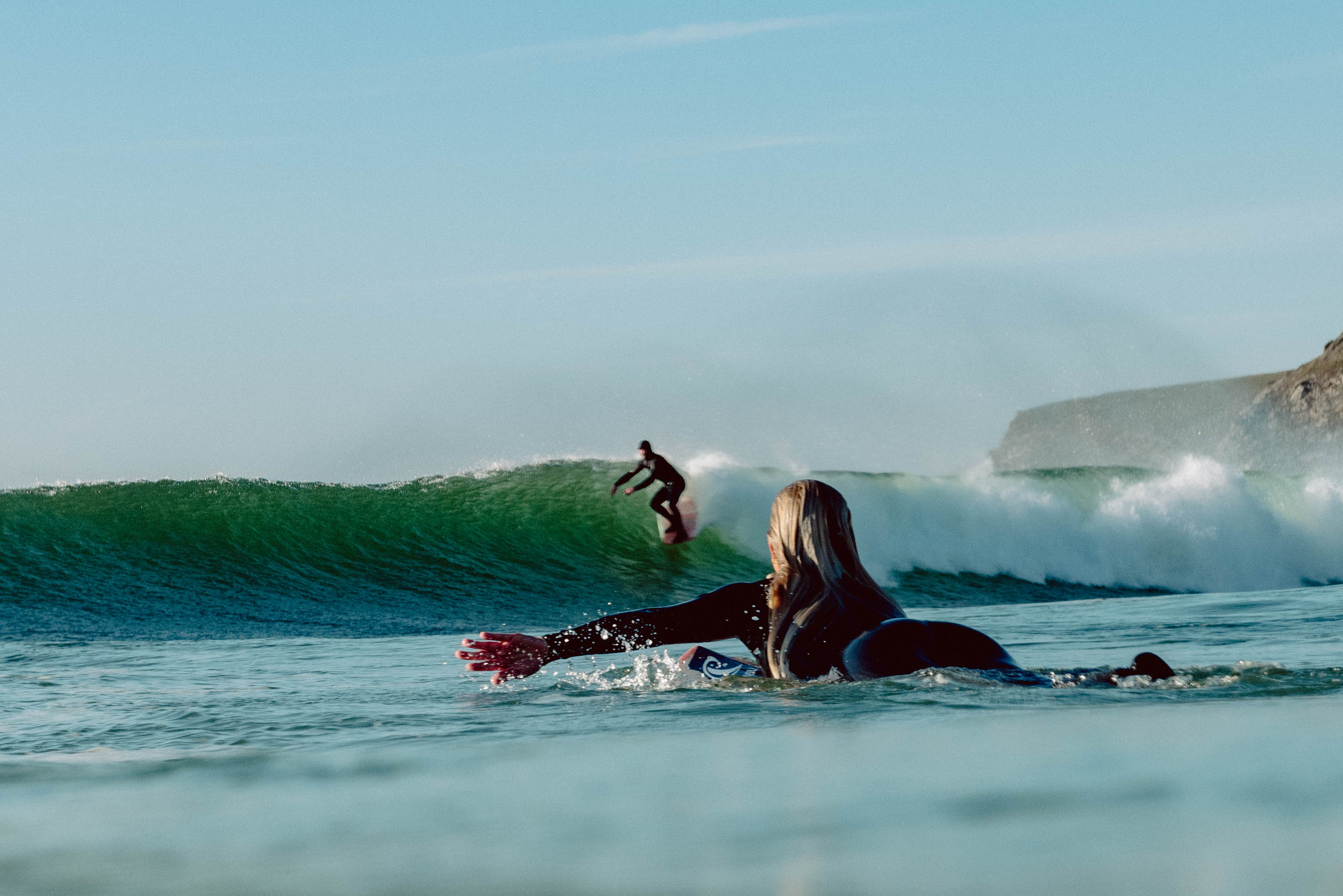 A surfer looking at the wide range of high-quality wetsuits for all seasons at Noordzee Boardstore. Noordzee Boardstore surfshop Surfschool webshop surfboardrepairs Scheveningen
