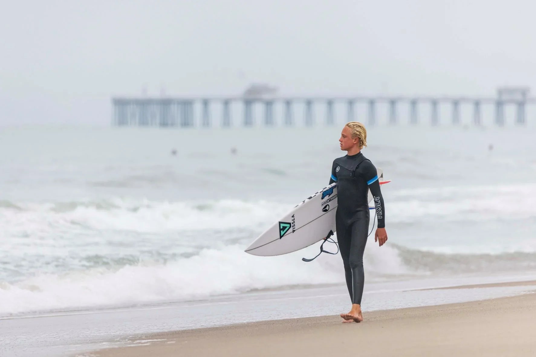 Young surfer ready for a spring session in a quality 4/3mm junior wetsuit from Noordzee Boardstore. Noordzee Boardstore surfshop Surfschool webshop surfboardrepairs Scheveningen