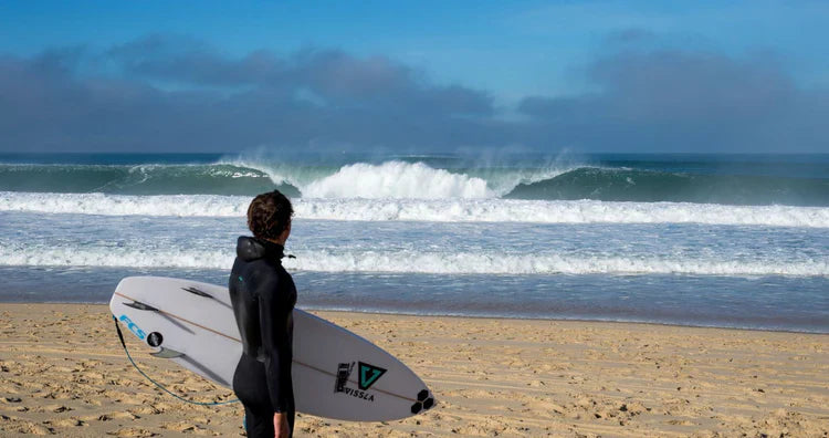 Man in a thick 5+mm winter wetsuit from Noordzee Boardstore, prepared for the coldest North Sea waves. Noordzee Boardstore surfshop Surfschool webshop surfboardrepairs Scheveningen