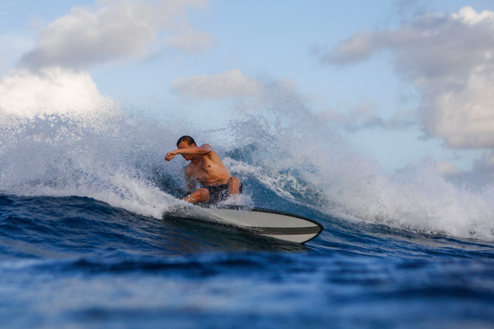 A surfer with a retro fish board from Noordzee Boardstore, perfect for North Sea waves. Noordzee Boardstore surfshop Surfschool webshop surfboardrepairs Scheveningen