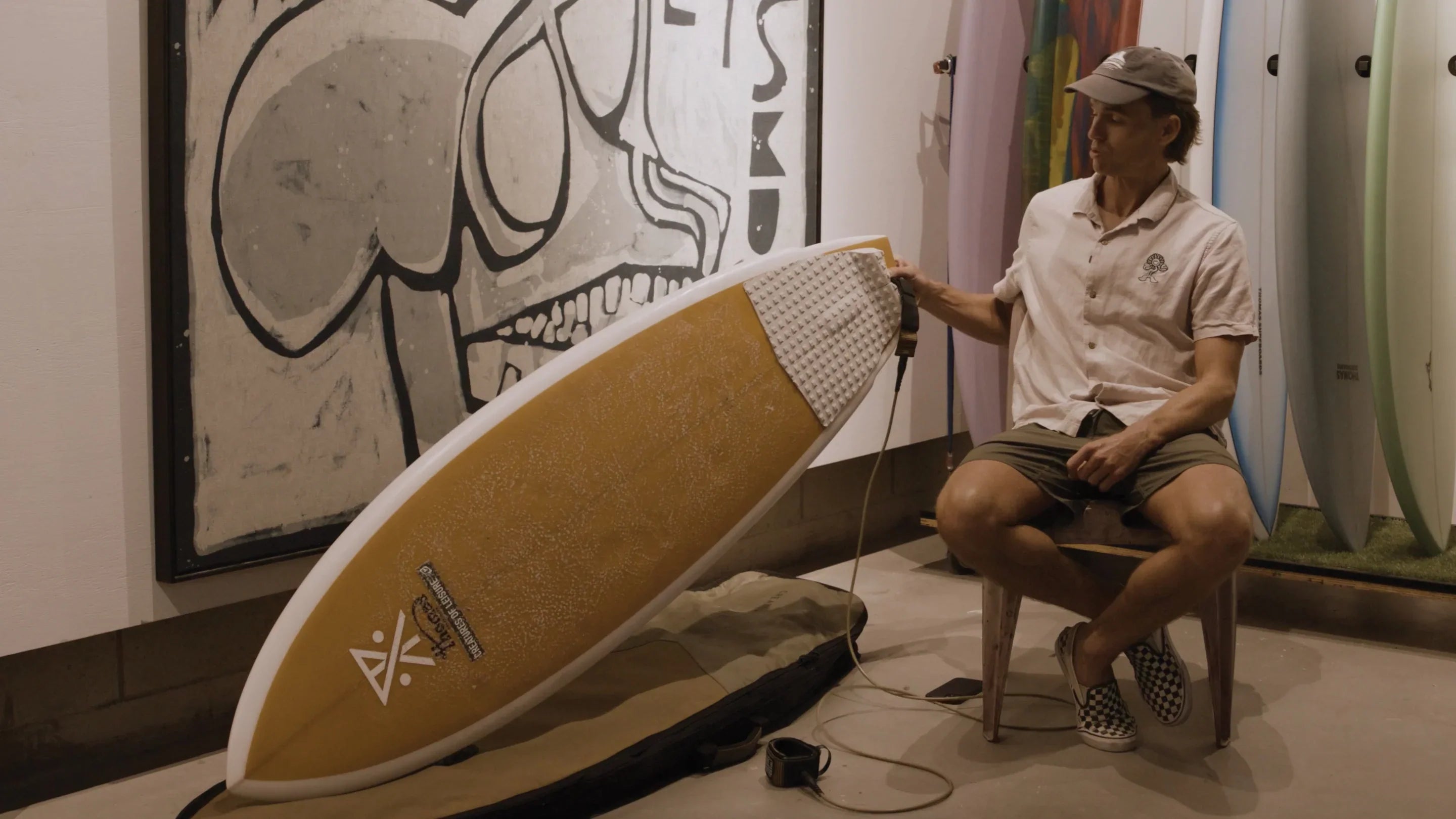 Surfer applying a new traction pad to their board for extra grip, available at Noordzee Boardstore. Noordzee Boardstore surfshop Surfschool webshop surfboardrepairs Scheveningen