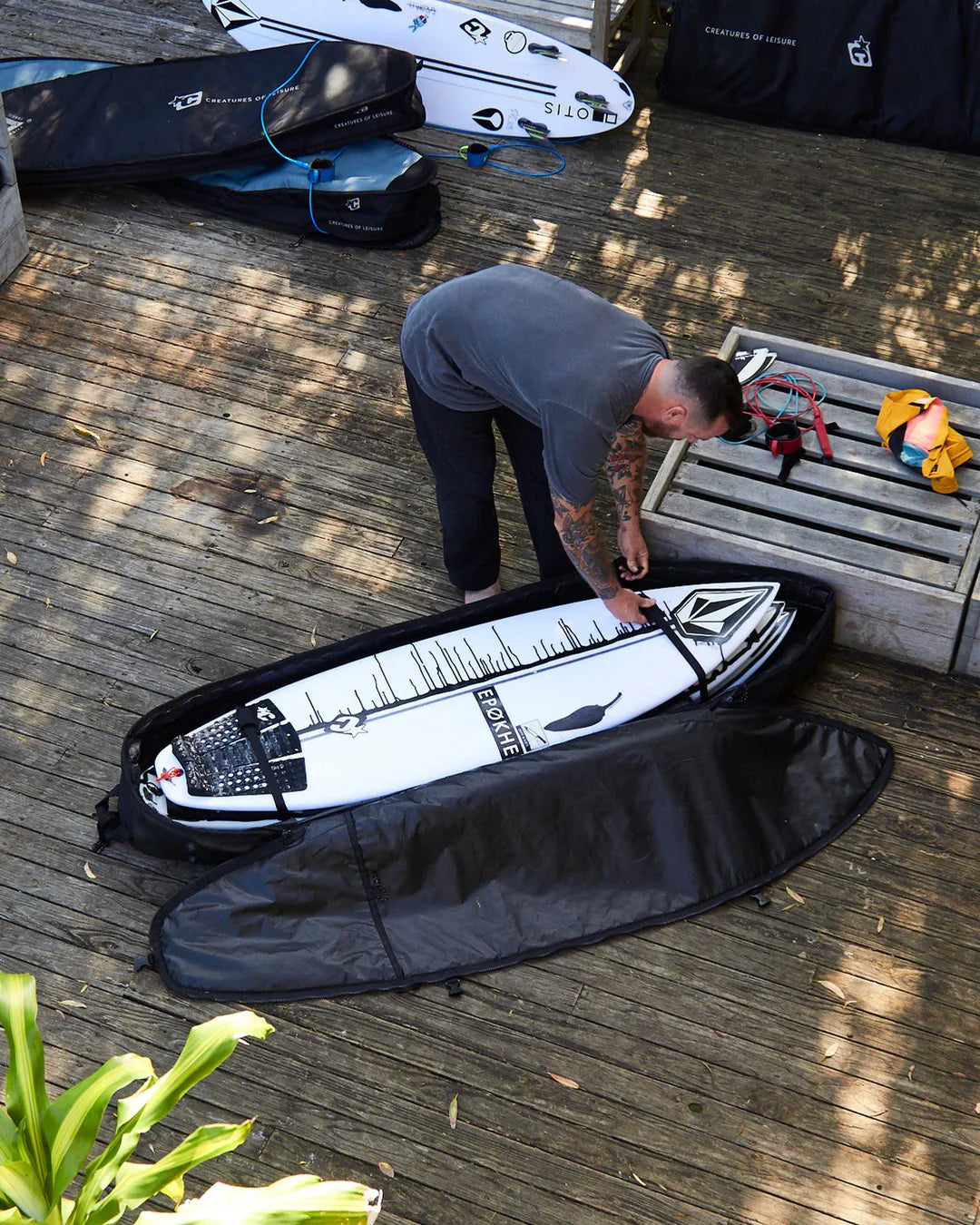 A person carrying their surfboard in a padded single boardbag from Noordzee Boardstore. Noordzee Boardstore surfshop Surfschool webshop surfboardrepairs Scheveningen